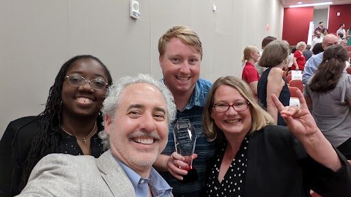 NC State CIO Marc Hoit poses for selfie with University Awards for Excellence winner Brandon Bouché (middle) pictured next to finalists Adria Snead (left) and Elizabeth Cole-Walker (right) at the in-person campus ceremony.