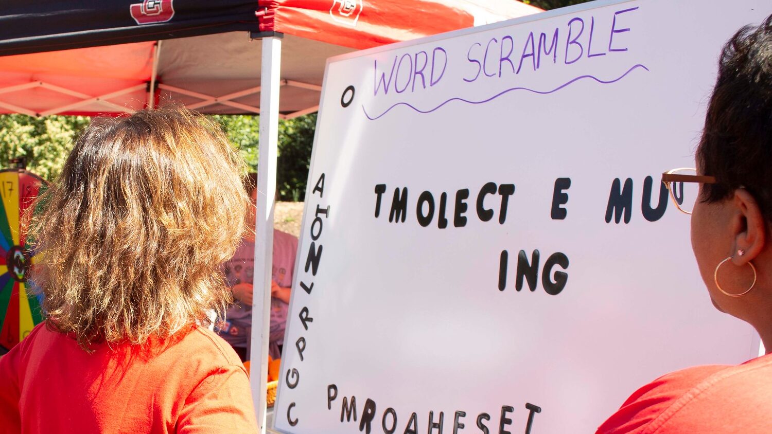 Janice Sitzes and April Jones work together to unscramble words during the NC State Earth Fair.