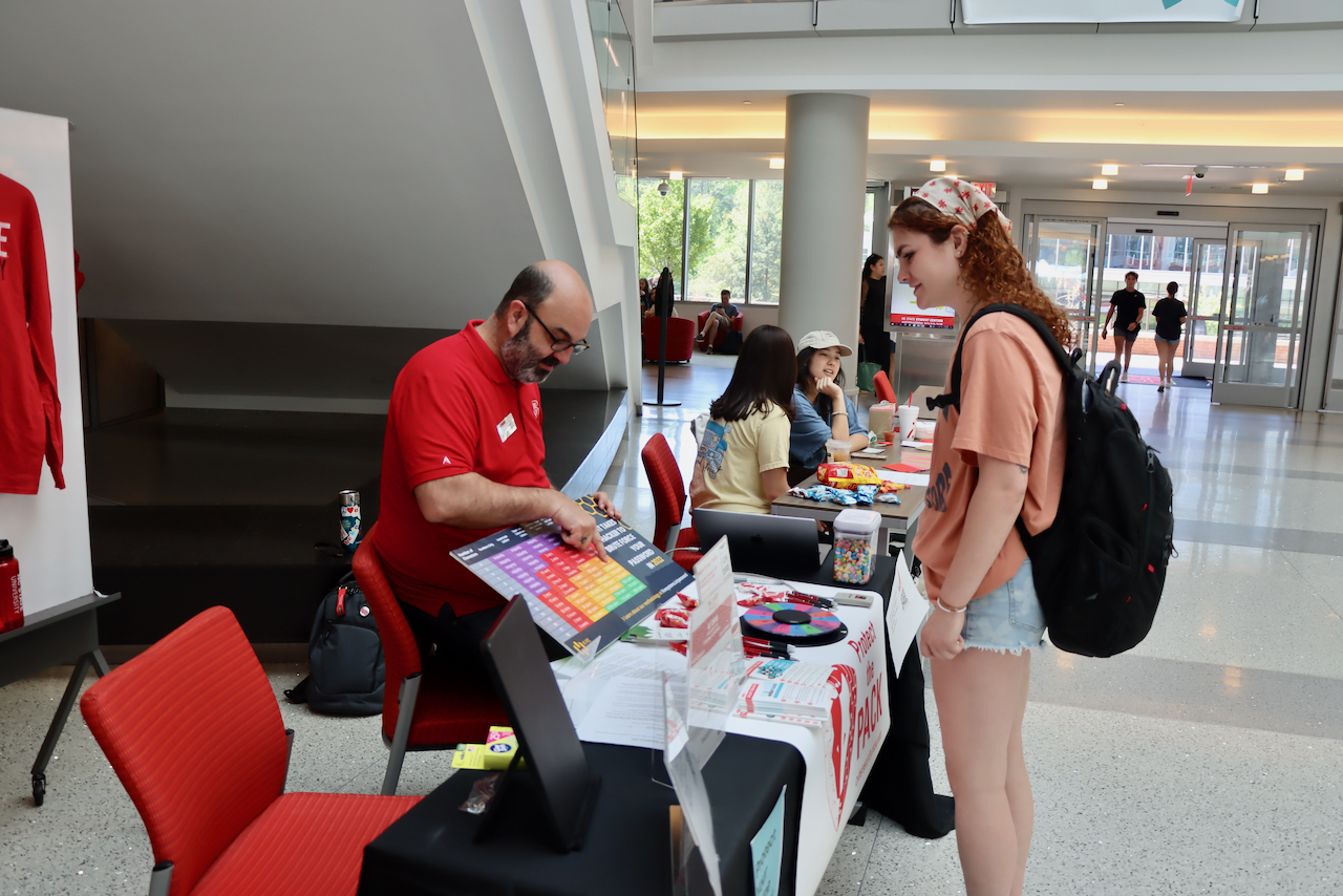 Bill Rodriguez talks to a student about IT security at a tabling event in Talley Student Union.