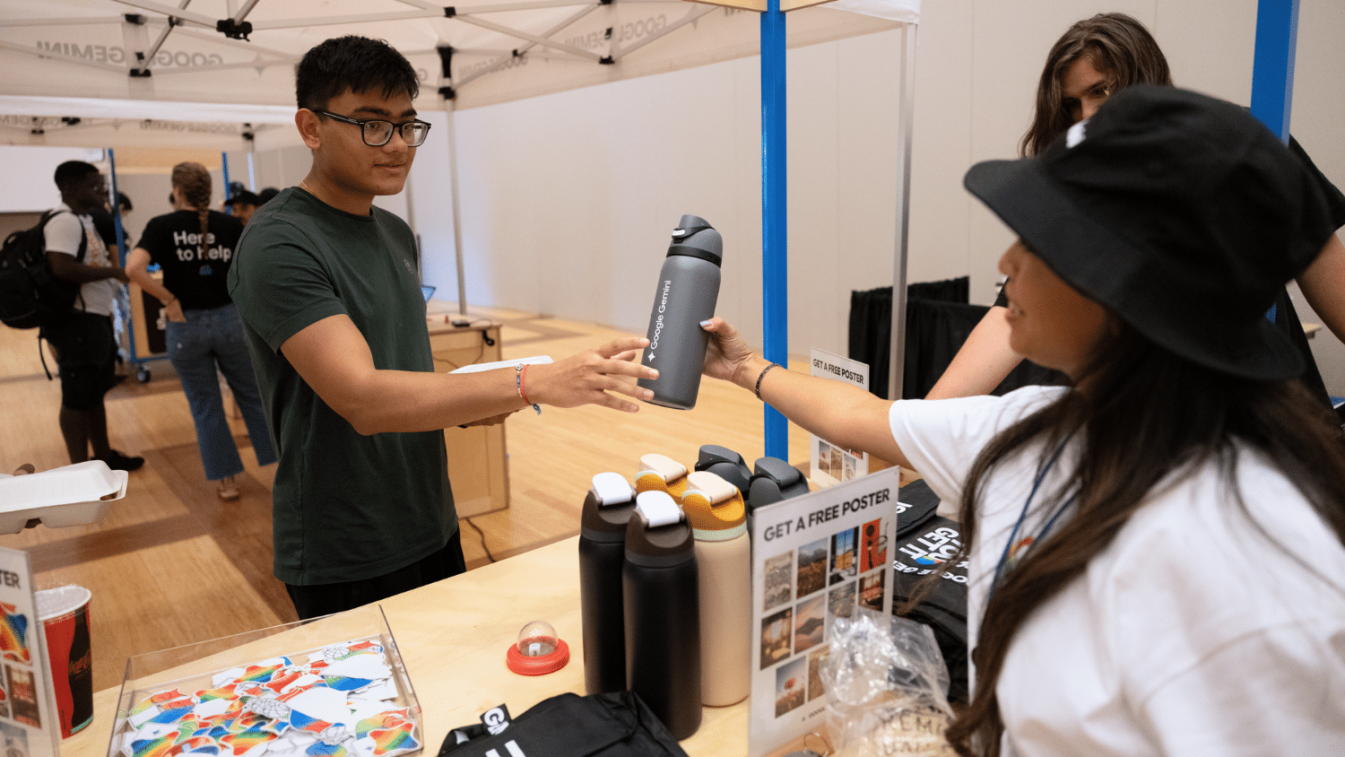 A student receives a water bottle from a Google staff member.
