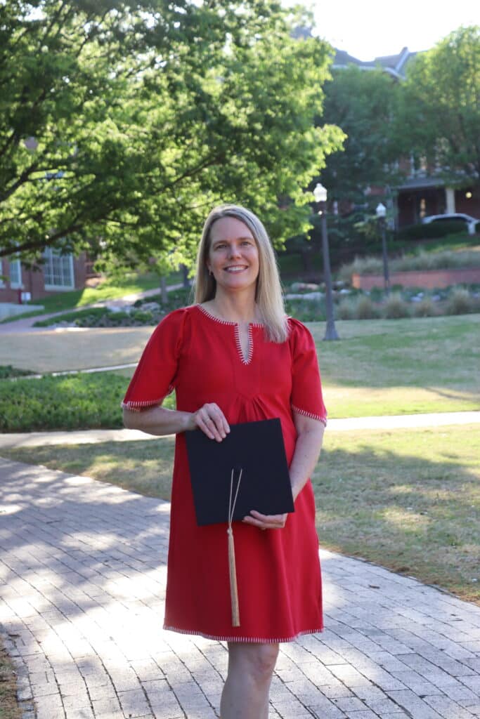 Stephanie Jackson stands in the Court of North Carolina while holding a graduation cap